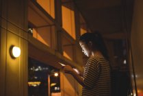 Mujer joven usando tableta digital en el paso por la noche - foto de stock