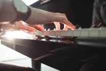 Primo piano di Donna che suona un pianoforte in studio di musica — Foto stock
