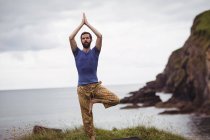 Mann macht Yoga auf Klippe — Stockfoto