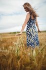 Bella donna che tocca il grano in campo — Foto stock