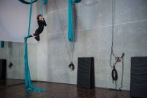 Turnerin turnt im Fitnessstudio auf blauem Stoffseil — Stockfoto