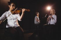 Trois étudiantes jouant du piano, de la clarinette et du violon dans un studio — Photo de stock