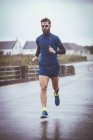 Спортсмен біжить по дорозі протягом дня — стокове фото