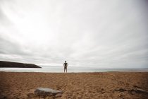 Vue arrière de l'homme debout sur la plage — Photo de stock