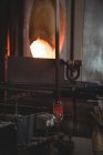 Close-up of molten glass on blowpipe at glassblowing factory — Stock Photo