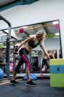Hermosa mujer levantando pesas en el gimnasio - foto de stock
