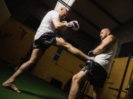 Низький кут зору двох тайських боксерів, що практикують бокс у спортзалі — стокове фото