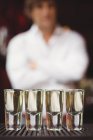 Primer plano de tequila en vasos de chupito en el mostrador de bar en el bar - foto de stock