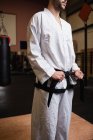 Immagine ritagliata di uomo in kimono karate in piedi in sala fitness — Foto stock