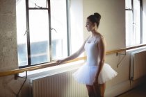 Ballerina tenendo bar in studio e guardando la finestra — Foto stock