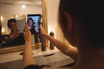 Женщина делает селфи с мобильного телефона в салоне красоты — стоковое фото