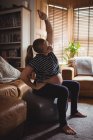 Schwangere macht Dehnübungen auf Fitnessball im heimischen Wohnzimmer — Stockfoto
