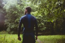 Visão traseira do atleta em pé na floresta — Fotografia de Stock