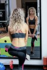 Красива жінка виконує вправи в спортзалі — стокове фото