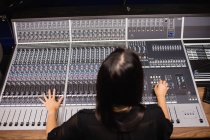Студентка использует звуковой микшер в студии — стоковое фото