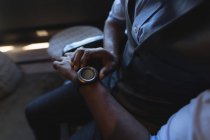 Средняя часть бизнесмена использует умные часы в офисе — стоковое фото