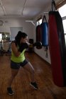 Joven boxeadora practicando boxeo en gimnasio - foto de stock
