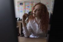 Durchdachte weibliche Führungskraft sitzt am Schreibtisch im Büro — Stockfoto