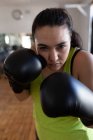 Young female boxer practicing boxing in fitness studio — Stock Photo