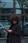 Afro-Frau benutzt Handy in der Stadt — Stockfoto