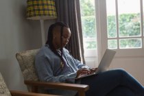 Las mujeres que utilizan el ordenador portátil en una sala de estar en casa - foto de stock