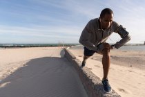 Atleta di sesso maschile che si esercita sulla parete circostante vicino alla spiaggia — Foto stock
