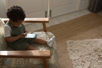 Kind benutzt Handy zu Hause — Stockfoto
