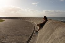 Joggerin lehnt an sonnigem Tag an Mauer — Stockfoto