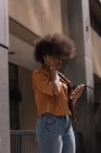 Жінка слухає музику на мобільному телефоні в місті — стокове фото