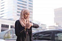 Femme Hijab en utilisant la montre intelligente en ville — Photo de stock