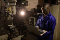 Arbeiter benutzt Laptop in Glasfabrik — Stockfoto