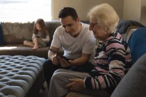 Мати і син використовують цифровий планшет на дивані у вітальні вдома — стокове фото