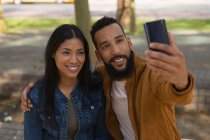 Счастливая пара делает селфи на мобильном телефоне в городе — стоковое фото
