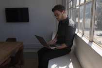 Мужчина, использующий ноутбук в офисе — стоковое фото