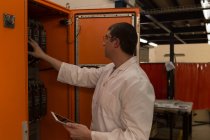 Robotics engineer examining control panel in warehouse — Stock Photo