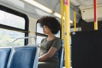 Продумана жінка дивиться крізь вікно в автобусі — стокове фото