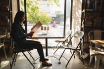 Вид збоку жінки, дивлячись на меню в кафе — стокове фото