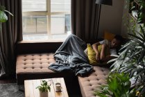 Homme dormant sur canapé dans le salon à la maison — Photo de stock