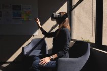 Бизнесвумен, использующая гарнитуру виртуальной реальности в офисе — стоковое фото