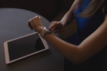 Milieu de section de l'exécutif féminin en utilisant smartwatch dans le bureau — Photo de stock