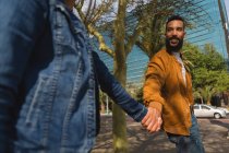 Glückliches Paar hält Händchen in der Stadt — Stockfoto