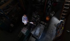 Накладные расходы работника мужского пола с помощью сварочной горелки на стекольном заводе — стоковое фото