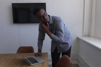 Exécutif masculin réfléchi en utilisant un ordinateur portable dans le bureau — Photo de stock