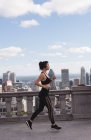 Жінка біжить по місту в сонячний день — стокове фото