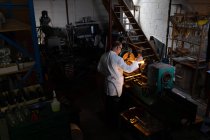 Чоловічий працівник використовує зварювальний факел на скляній фабриці — стокове фото