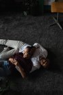 Пара розслабляється на підлозі у вітальні вдома — стокове фото