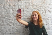 Руда жінка беручи selfie в кафе — стокове фото
