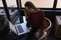 Hermosa mujer de negocios utilizando el ordenador portátil en la oficina - foto de stock