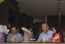 Бабушка и дедушка празднуют дома день рождения своих внучек — стоковое фото
