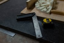 Primer plano de prueba cuadrada y cinta métrica en taller de fundición - foto de stock